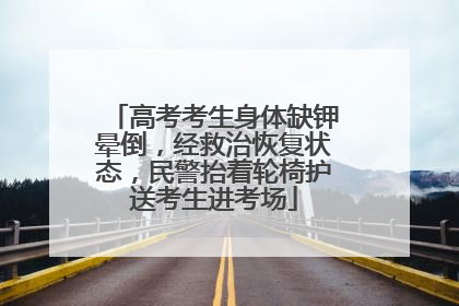 高考考生身体缺钾晕倒，经救治恢复状态，民警抬着轮椅护送考生进考场